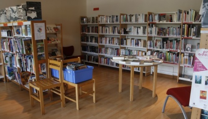 espace de collections composé de rayonnages et de tables de présentations