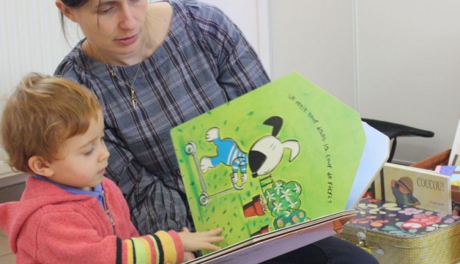bibliothécaire lisant un album à un enfant