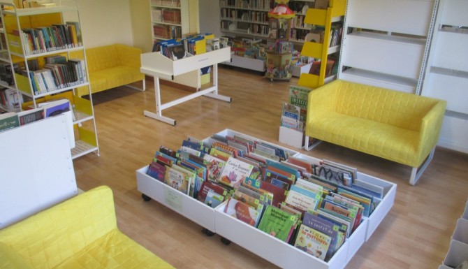 les espaces de la bibliothèque. Canapés jaunes et mobiliers blancs