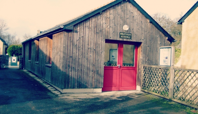 Extérieur de la bibliothèque, bardée de bois, porte rouge