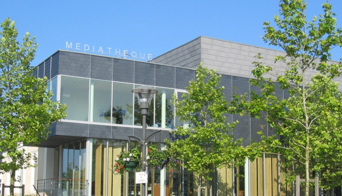 vue du bâtiment. Très contemporain avec des formes rectangulaires marquées. Couleur grise majoritaire
