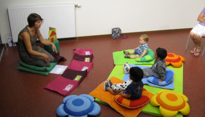 animation enfant avec une bibliothécaire et des enfant ssur des tapis en formes de fleurs de couleurs vives