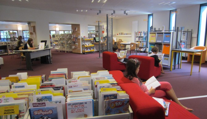 espaces de la bibliothèque. Mobilier blanc, tapis et assises rouges