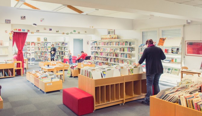 autre vue du coin enfants, avec des bacs, des usagers et des mobiliers rouges