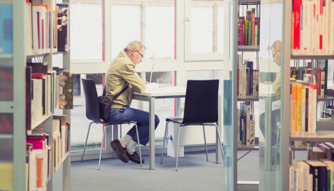 une personne assise à une table est en train de lire