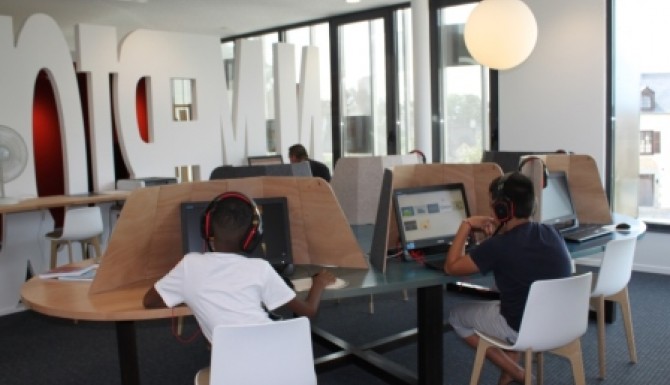 Espace multimédia. enfants autour d'ordinateur