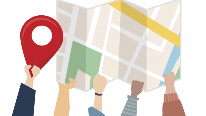 CC0 Freepik. Illustration de mains portant un plan et une punaise de localisation.