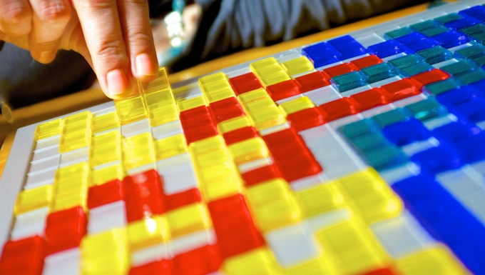 a_board_game_impersonating_a_video_game_cc_by-nc_2.0_by_jamie_mccaffrey Jeu de plateau surplombé d'une main positionnant un élément