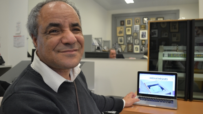 Abder Ragui Portrait d'Abder ragui devant un ordinateur portable affichant l'accueil d'une portail des médiathèques de Rennes métropole