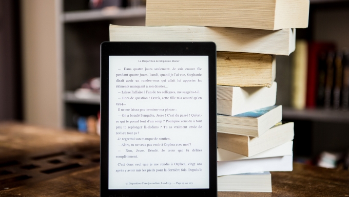 Les liseuses. CC0 - Pixabay. Une liseuse posée à côté d'une pile de livres.
