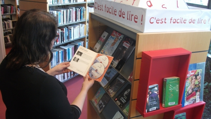 Facile à Lire. Tous droits réservés. Personne consultant un document issu d'un présentoir "Facile à lire"