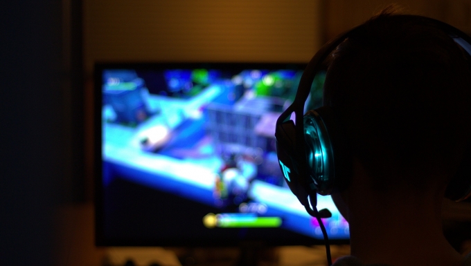 Jeux vidéo. CC0 - Pixabay. Une personne de dos jouant dans la pénombre à un jeu vidéo.