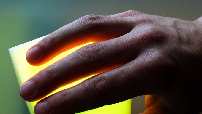 Confort plus. Une main posée sur un carré luminescent.