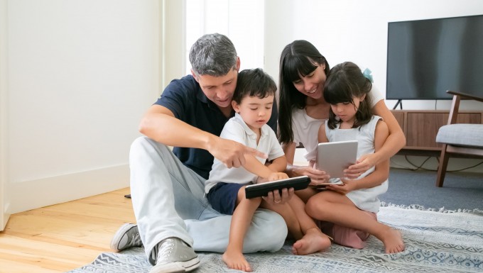 CC0 Freepik. Photo d'une famille réunie autour de tablettes numériques.