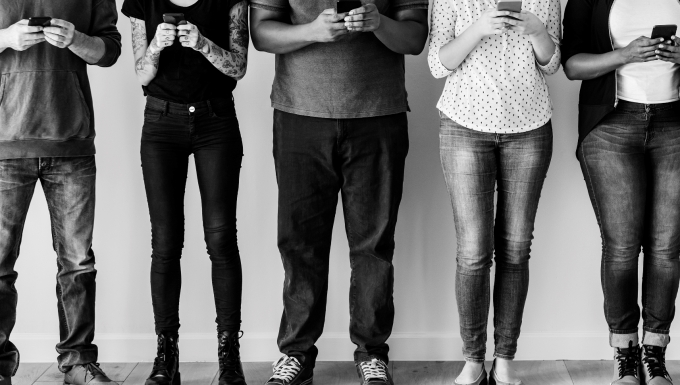Designed by rawpixel.com / Freepik. Photo en noir et blanc de personnes consultant leur téléphone portable.