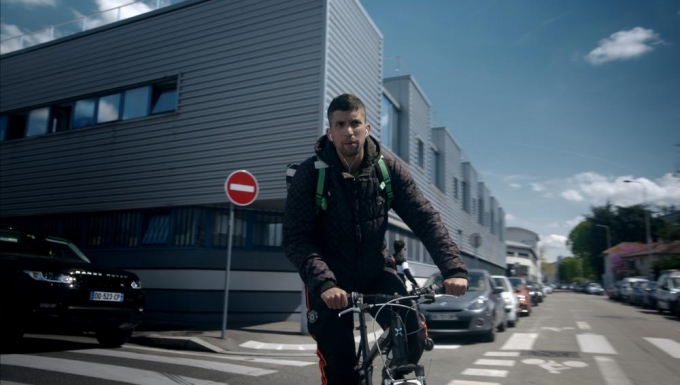 France.tv Slash. Tous droits réservés. Un livreur roulant à vélo.