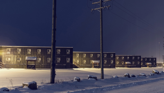 Fort McMoney. 3 immeubles sous la neige vus de nuit.