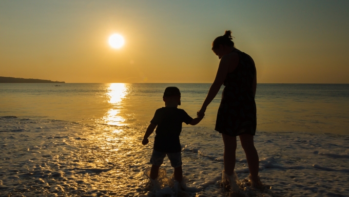 CC0 Public Domain. Source : httpspixabay.comfrsunset-mer-plage-abendstimmung-2943947 Silhouettes d'une mère et de son enfant marchant sur un rivage au crépuscule.