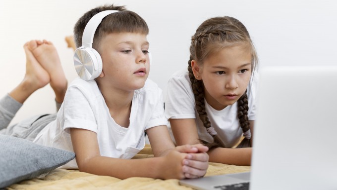 CC0 Freepik. Deux enfants regardant l'écran un ordianteur portable.
