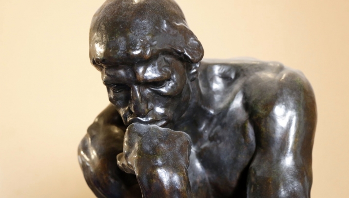 Gros plan de la sculpture en bronze "Le Penseur" d'Auguste Rodin.