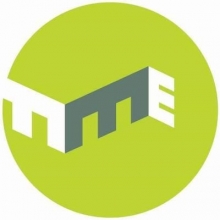 Logo Le Muz. Lettres stylisées blanches et grises sur un cercle vert.