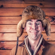Homme coiffé d'un bonnet en fourrure de castor, souriant