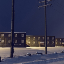 3 immeubles sous la neige vus de nuit.