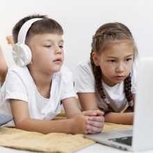 Deux enfants regardant l'écran un ordianteur portable.