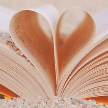 Livre plié en forme de coeur, posé sur plage