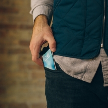 Homme sortant un téléphone portable de sa poche.